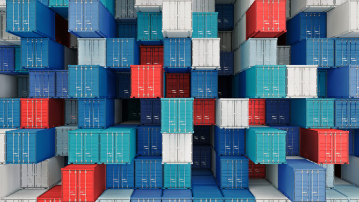 Cargo containers stacked in a warehouse in a shipping port.