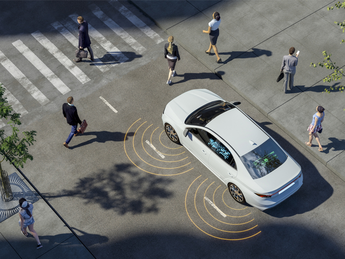 An autonomous vehicle drives through a busy city intersection