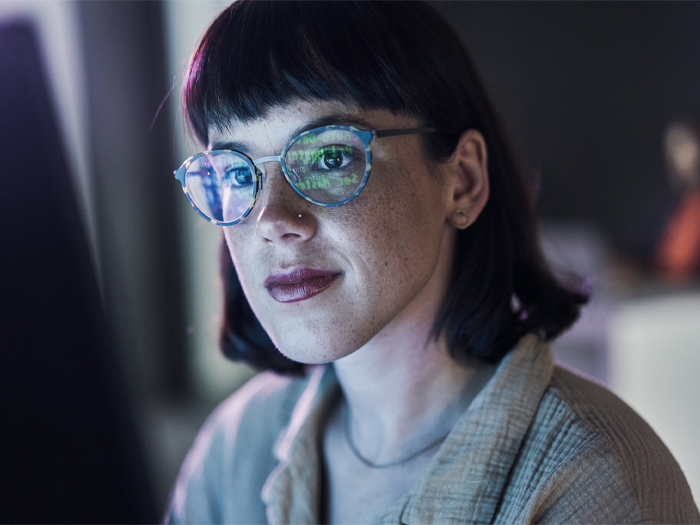 A woman sits in front of a computer screen