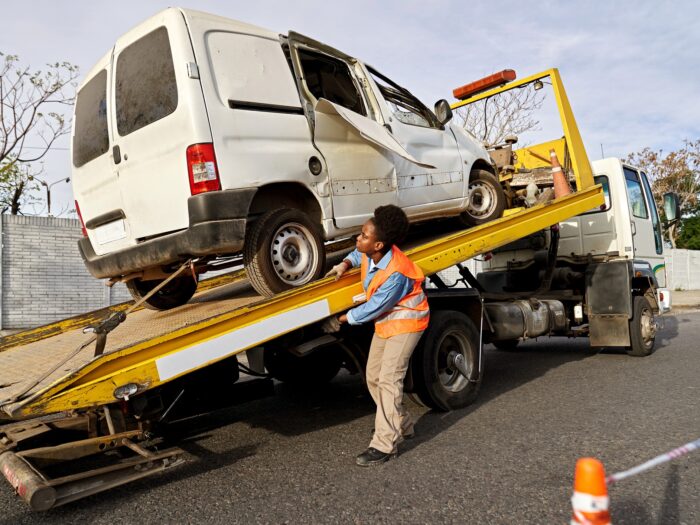 Towing service removing damaged van from crash site