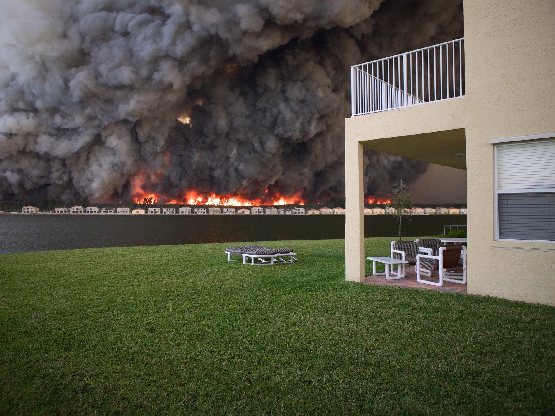 Forest fire behind lakefront houses in Miramar, Florida