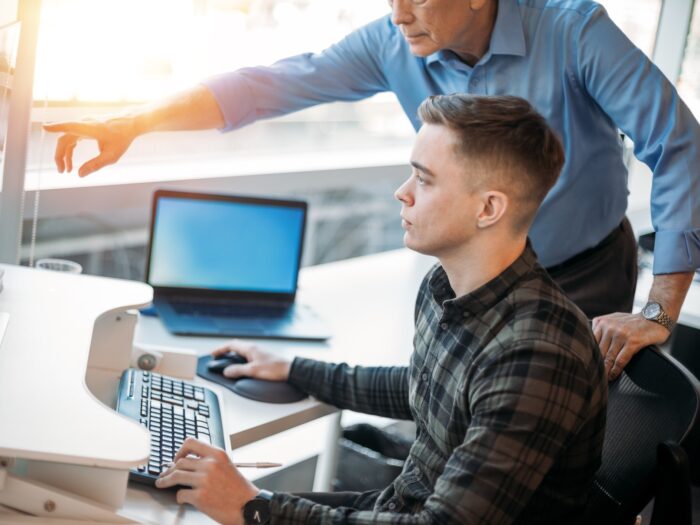 olleague mentoring younger associate in business office