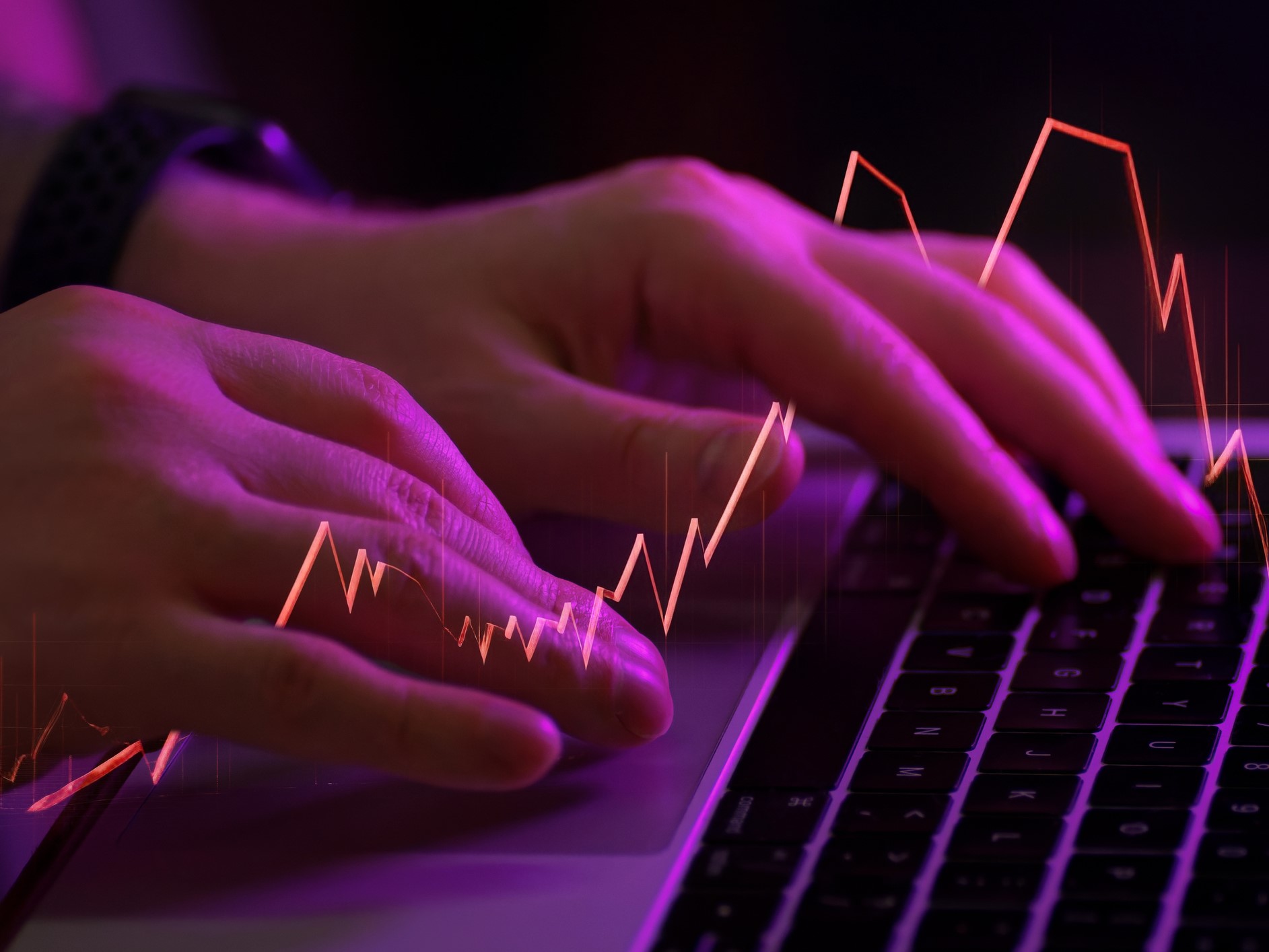 Close Up Of Male Hands Typing On Laptop Keyboard in Neon Light