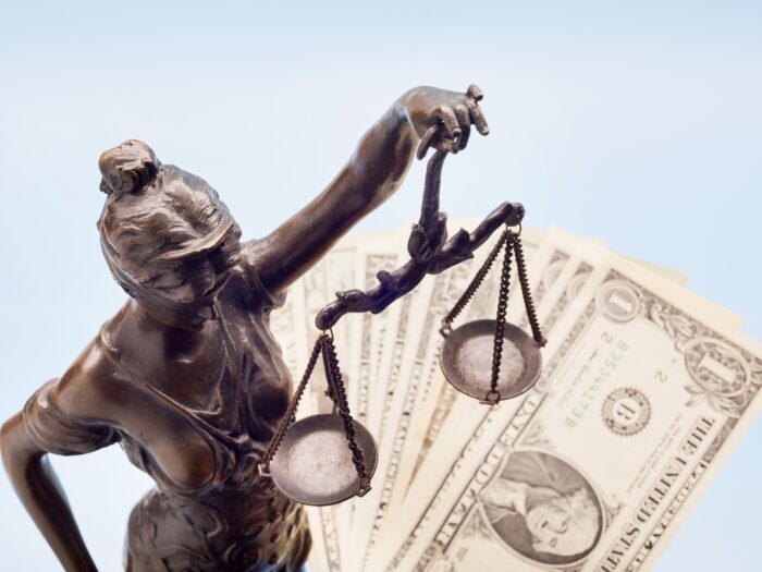 Lady Justice and American Dollar banknotes against blue background