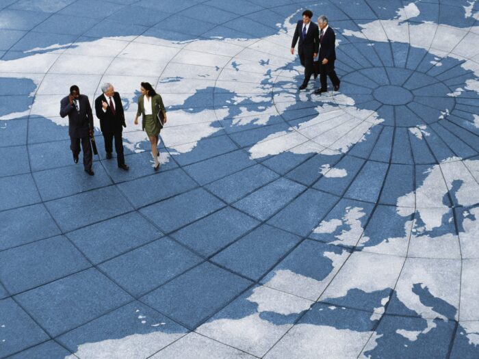 Businesspeople walking on map of globe