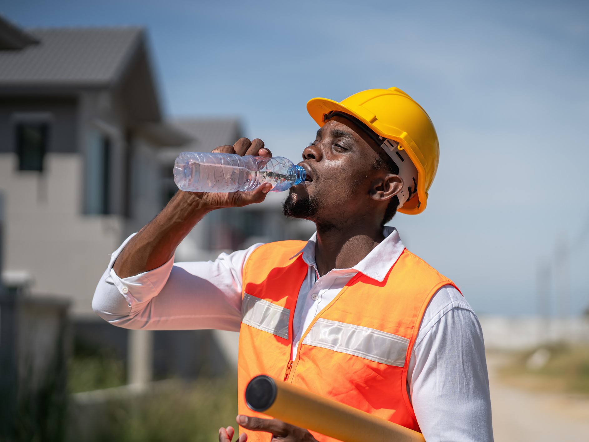 onstruction workers are drinking water thirstily due to the scorching hot weather