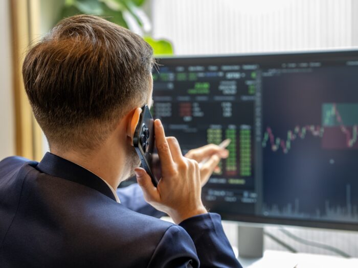 Stockbroker analyzing market charts on a computer screen
